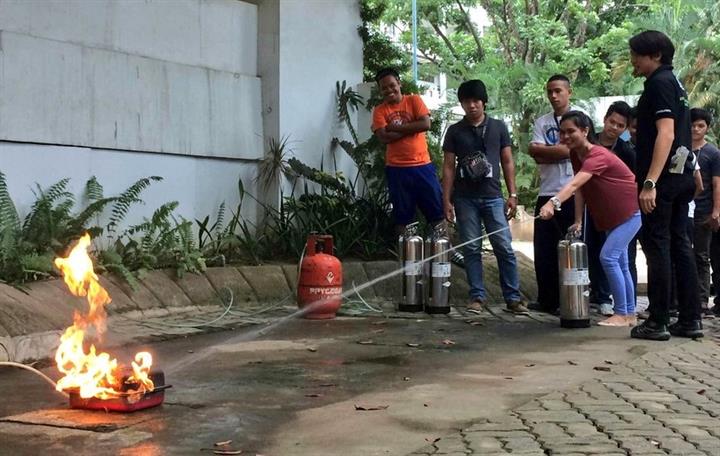 A student tries her hand at using a fire extinguisher during the TNT Tropang Ready “training of trainers” activity at USTP-CDO. Smart provides CDO students emergency response training
