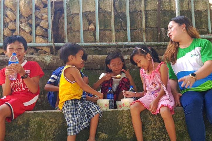 Children at the evacuation center in Cabungahan, Naga, enjoy hot meals served by Smart employee-volunteers. Smart provides communications, relief aid to Cebu landslide survivors