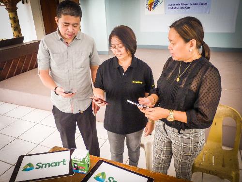 DyLA station manager Jhunnex Napallacan and SunStar director of content Nini Cabaero inspect the phones turned over by Smart public affairs junior manager NN Navarro. PLDT, Smart provide communications support for 2019 elections