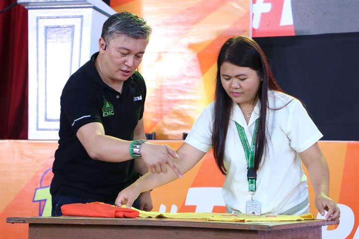 Louie Domingo of EMC demonstrates preparedness tips with the help of an HNU student. Smart taps Bohol youth for disaster preparedness
