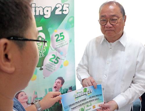 Pangilinan hands over a ceremonial check for P25M to the winner of the Smart Amazing 25 raffle promo. ‘Yolanda’ survivor wins P25M