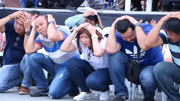 Participants assume the “duck, cover, and hold” position at the national earthquake drill in San Mateo, Rizal. Smart deploys communication tools at Rizal quake drill