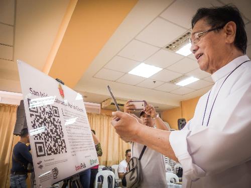 Dumaguete Bishop Julito Cortes scans the QR code for Siquijor’s San Isidro Labrador Parish Church or Lazi Church. Smart supports celebration of 500 years of Christianity in PH