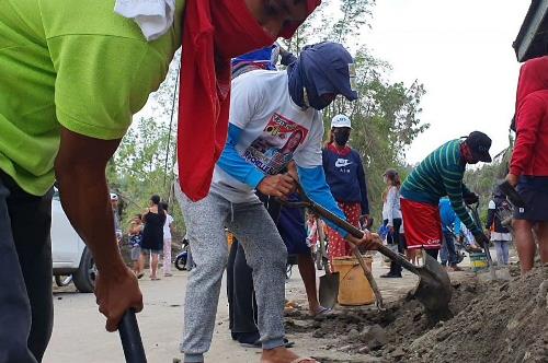 A month after the eruption of the Taal Volcano, residents in Barangay Buso-Buso, Laurel, Batangas, are still clearing the roads of ashfall. Taal communities receive livelihood, shelter aid