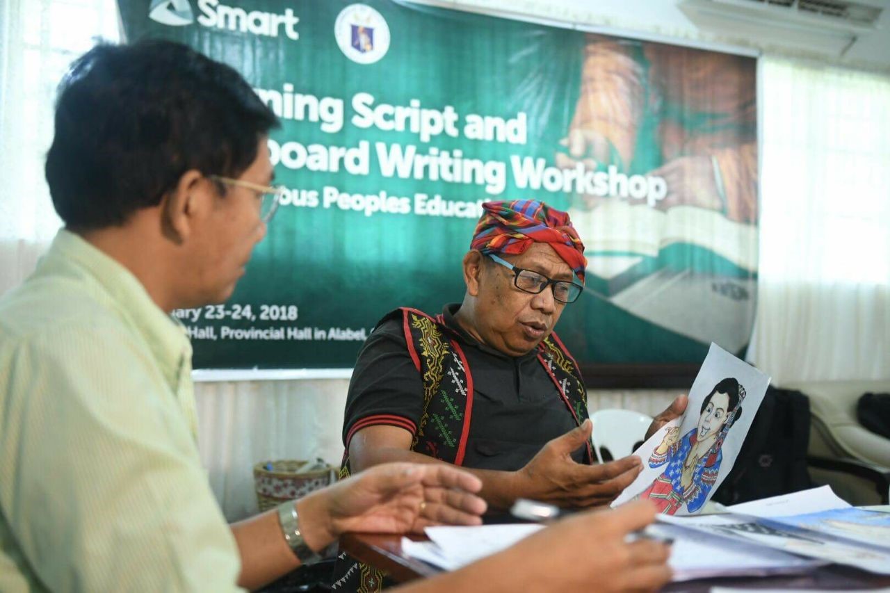 IP students to benefit from localized learning content An elder of the Blaan tribe in Sarangani checks the accuracy of illustrations and learning content created by teachers for young Blaan learners.